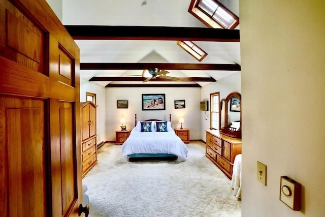 bedroom with lofted ceiling with skylight, baseboards, and light carpet