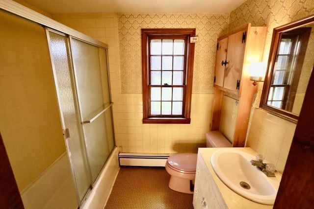 bathroom featuring a baseboard radiator, a healthy amount of sunlight, wallpapered walls, and tile walls