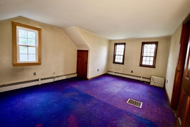 additional living space featuring baseboard heating, visible vents, lofted ceiling, and carpet