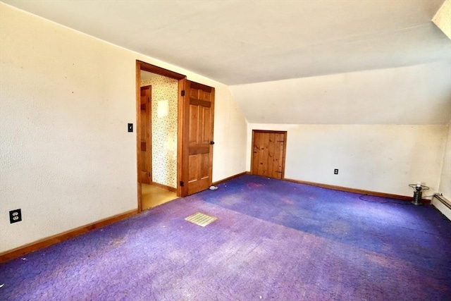 additional living space featuring carpet floors, lofted ceiling, and baseboards