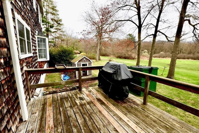 wooden terrace featuring an outdoor structure and a yard