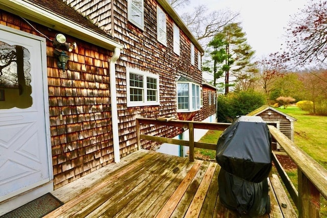 wooden deck with an outdoor structure and a storage shed