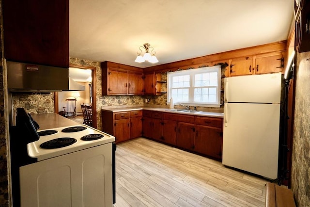 kitchen with white appliances, light wood-style flooring, light countertops, brown cabinets, and a sink