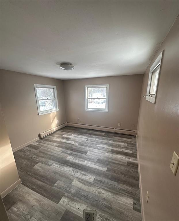 spare room with dark wood-type flooring and plenty of natural light