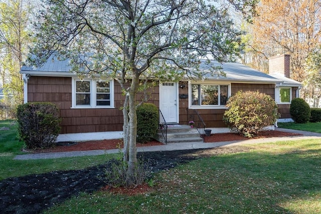 single story home featuring a front lawn and a chimney