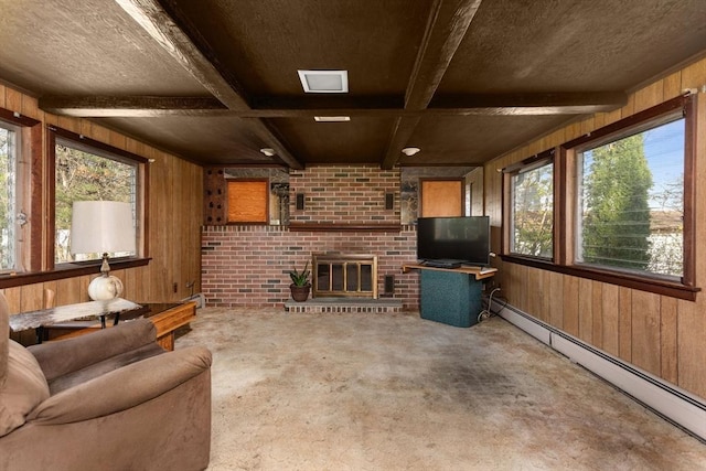 unfurnished living room with wood walls, concrete flooring, baseboard heating, and a wealth of natural light