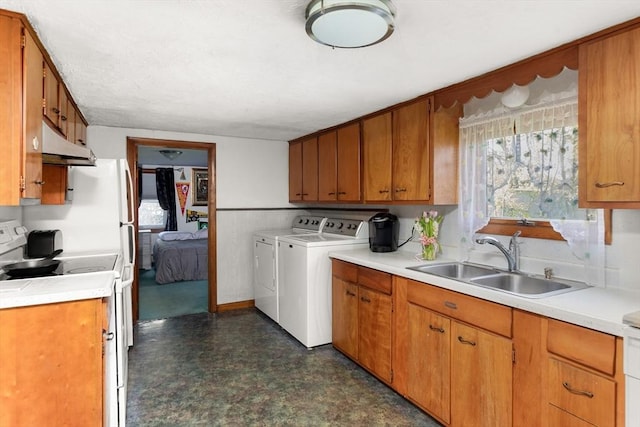 washroom featuring laundry area, a sink, dark floors, and washer and clothes dryer