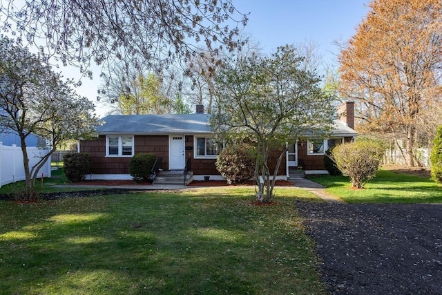 ranch-style house featuring fence, a chimney, and a front yard