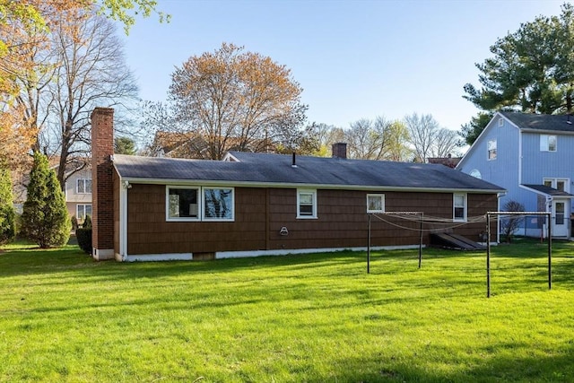 rear view of house featuring a lawn and a chimney