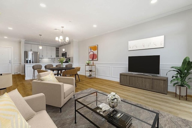 living room with crown molding, recessed lighting, and a chandelier