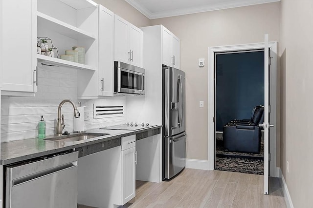 kitchen featuring backsplash, appliances with stainless steel finishes, open shelves, a sink, and white cabinets
