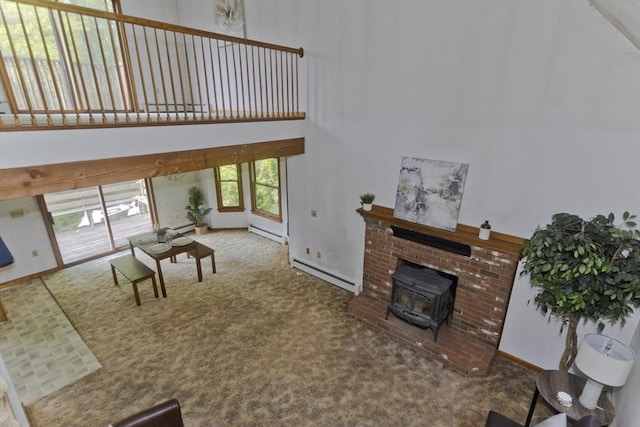 245 State Rd, Phillipston, MA 01331 - living room featuring a high ceiling, a wood stove, a baseboard heating unit, and carpet flooring