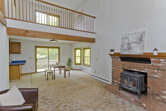 245 State Rd, Phillipston, MA 01331 - living room featuring a baseboard heating unit, carpet flooring, a wood stove, and a towering ceiling