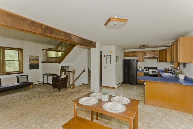 245 State Rd, Phillipston, MA 01331 - kitchen with black fridge, under cabinet range hood, stove, dark countertops, and brown cabinets