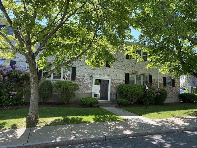 view of front of home with a front lawn and brick siding