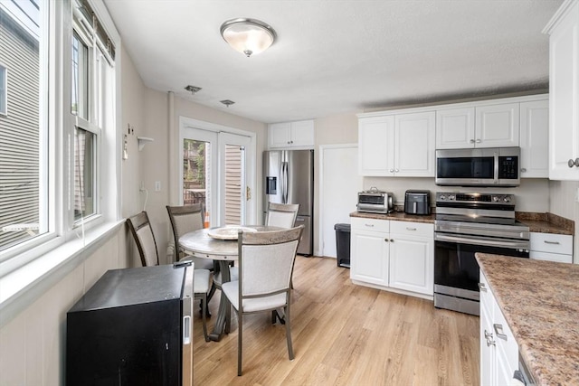 13 Knowlton St, Boston, MA 02127 - kitchen with appliances with stainless steel finishes, white cabinetry, and light wood-style floors