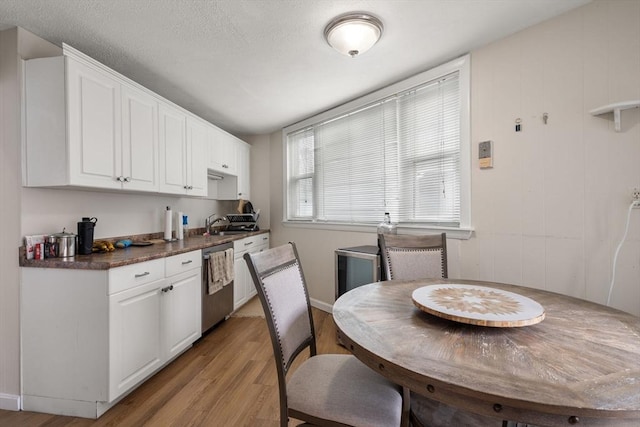 13 Knowlton St, Boston, MA 02127 - kitchen with stainless steel dishwasher, light wood-type flooring, white cabinets, dark countertops, and a sink