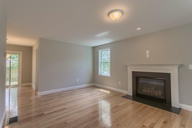 unfurnished living room with light wood-type flooring and plenty of natural light