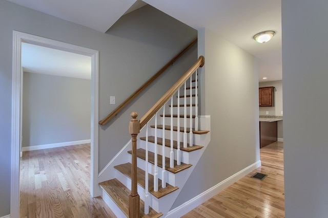 stairs featuring hardwood / wood-style flooring