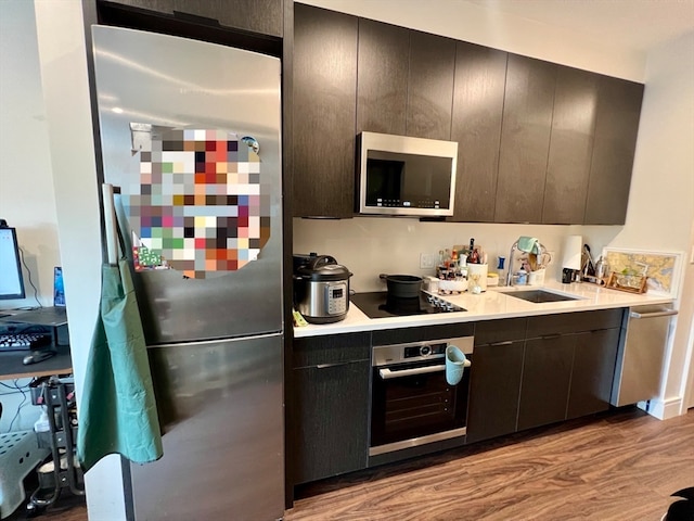 kitchen with sink, light hardwood / wood-style floors, and appliances with stainless steel finishes