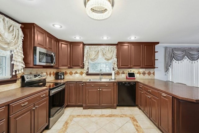 kitchen with tasteful backsplash, kitchen peninsula, sink, light tile patterned flooring, and stainless steel appliances