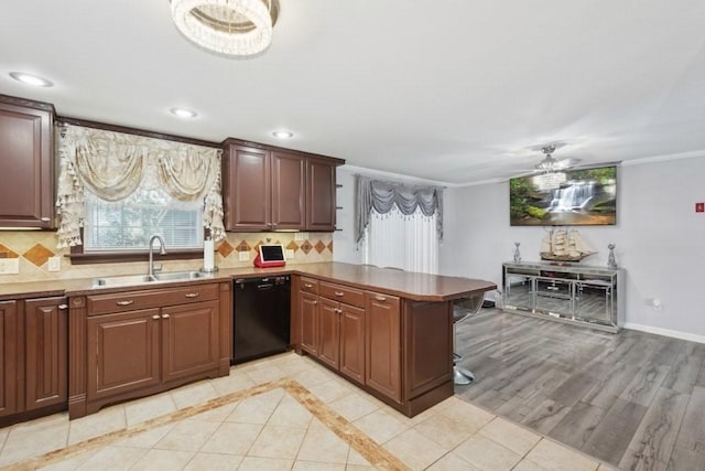 kitchen featuring backsplash, kitchen peninsula, dishwasher, and sink