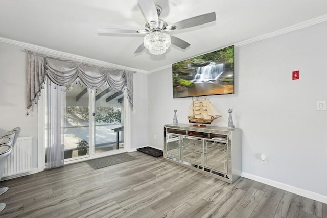 living room with hardwood / wood-style flooring, radiator, crown molding, and ceiling fan