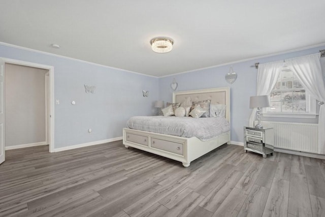 bedroom featuring ornamental molding and light hardwood / wood-style flooring