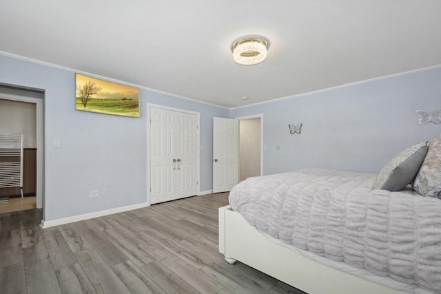 bedroom with crown molding and light hardwood / wood-style floors