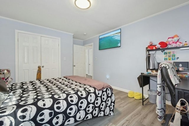 bedroom with light wood-type flooring, a closet, and ornamental molding