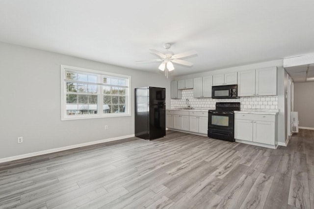 kitchen with ceiling fan, tasteful backsplash, black appliances, sink, and light wood-type flooring