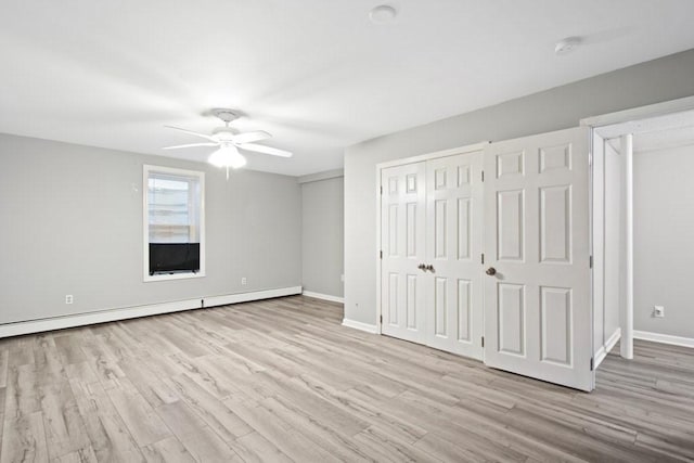 unfurnished bedroom with ceiling fan, baseboard heating, and light hardwood / wood-style flooring