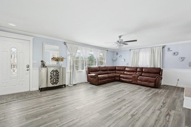 living room with ceiling fan, ornamental molding, and light hardwood / wood-style flooring