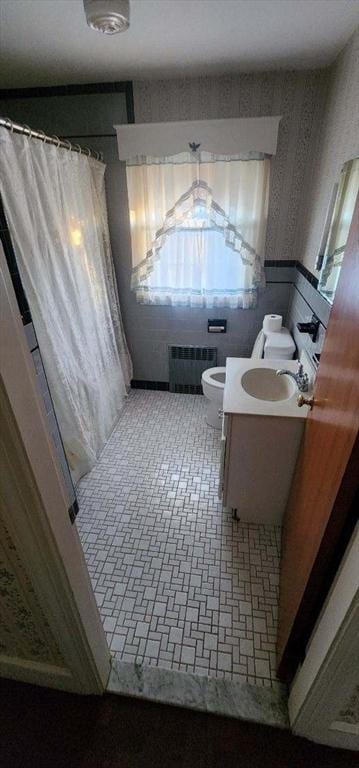 bathroom featuring vanity, toilet, and radiator