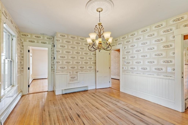 267 Pearl Hill Rd, Fitchburg, MA 01420 - unfurnished dining area featuring a baseboard radiator, light wood-style flooring, a chandelier, and arched walkways