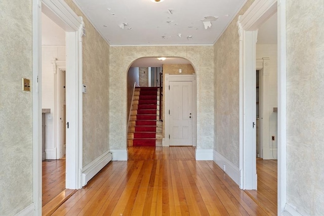 267 Pearl Hill Rd, Fitchburg, MA 01420 - hall featuring arched walkways, light wood-type flooring, crown molding, stairs, and a baseboard radiator