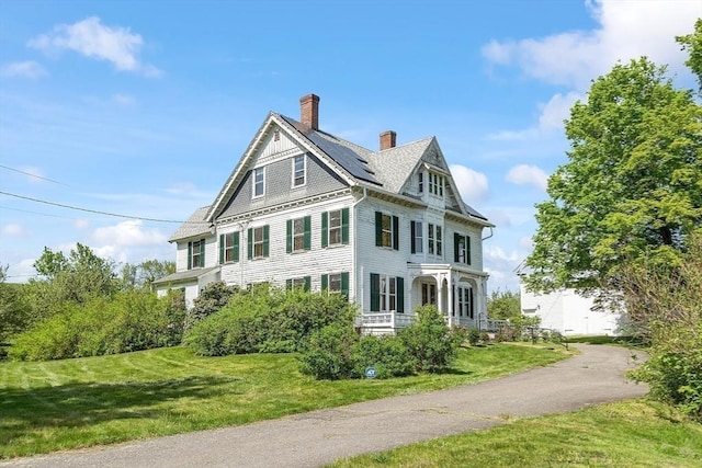 267 Pearl Hill Rd, Fitchburg, MA 01420 - view of side of property featuring a yard, roof mounted solar panels, a chimney, and covered porch