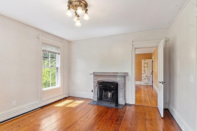 267 Pearl Hill Rd, Fitchburg, MA 01420 - unfurnished living room with a baseboard radiator, hardwood / wood-style flooring, a fireplace with flush hearth, baseboards, and a chandelier