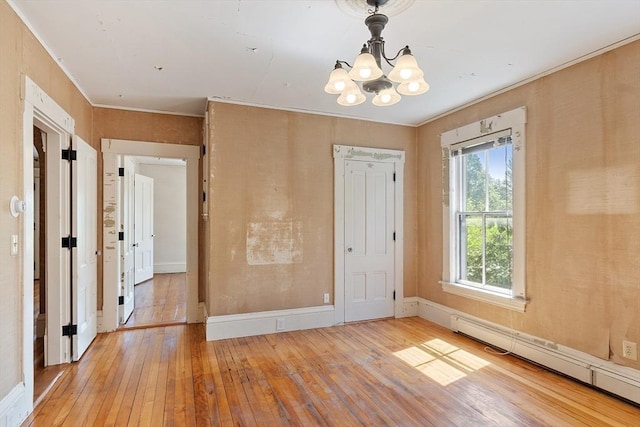 267 Pearl Hill Rd, Fitchburg, MA 01420 - empty room featuring a baseboard radiator, wood-type flooring, a chandelier, crown molding, and baseboards