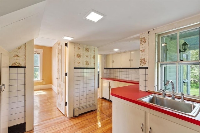 267 Pearl Hill Rd, Fitchburg, MA 01420 - kitchen featuring a baseboard heating unit, wallpapered walls, tile walls, light wood-style flooring, and a sink