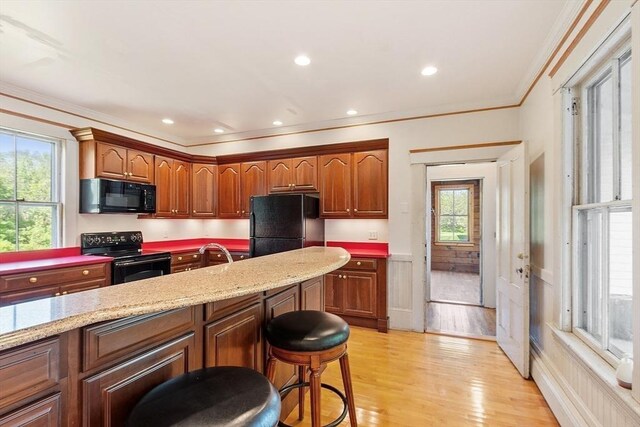 267 Pearl Hill Rd, Fitchburg, MA 01420 - kitchen with black appliances, crown molding, light wood finished floors, light stone countertops, and wainscoting