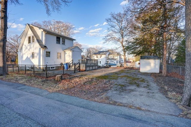 30 Royal St, Randolph, MA 02368 - view of property exterior featuring a storage unit, an outdoor structure, a wooden deck, and asphalt driveway