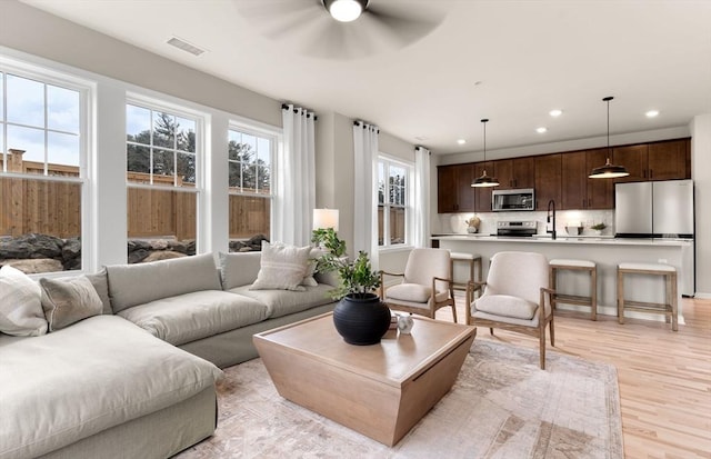 living room with recessed lighting, light wood finished floors, visible vents, and ceiling fan