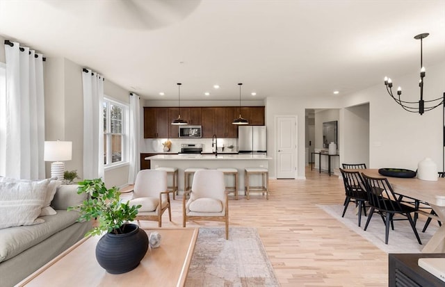 living room featuring light wood finished floors, an inviting chandelier, and recessed lighting