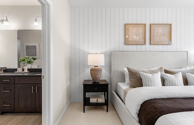bedroom with ensuite bath and baseboards