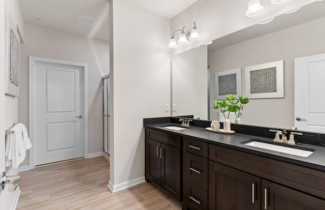bathroom with a sink, a shower stall, and wood finish floors