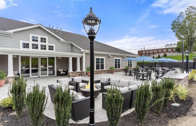 view of property's community with an outdoor living space with a fire pit and a patio area