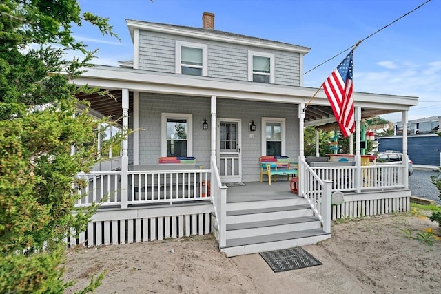 18 Marshfield Ave, Scituate, MA 02066 - view of front facade with a porch and a chimney
