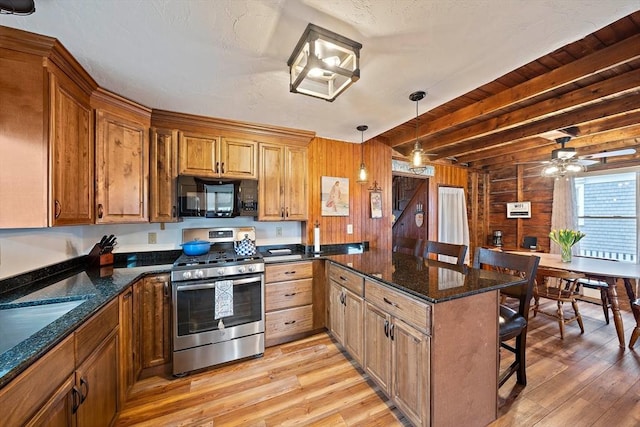 18 Marshfield Ave, Scituate, MA 02066 - kitchen featuring black microwave, stainless steel gas stove, a kitchen bar, light wood finished floors, and a peninsula