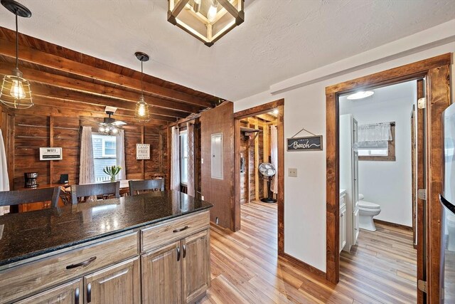 18 Marshfield Ave, Scituate, MA 02066 - kitchen with light wood finished floors, wooden walls, beamed ceiling, dark stone counters, and baseboards